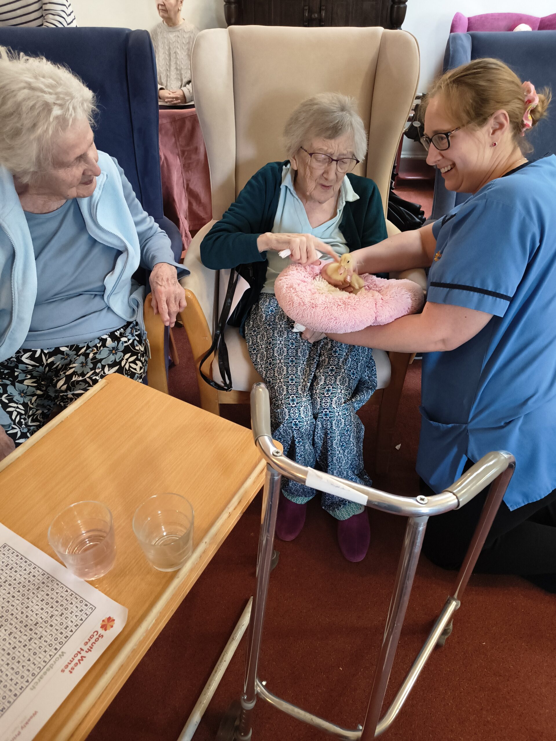 Residents and staff holding and stroking ducklings on the pink fluffy pillow9 scaled