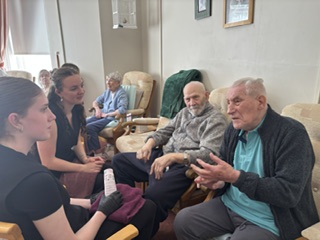 Residents and students seated together chatting