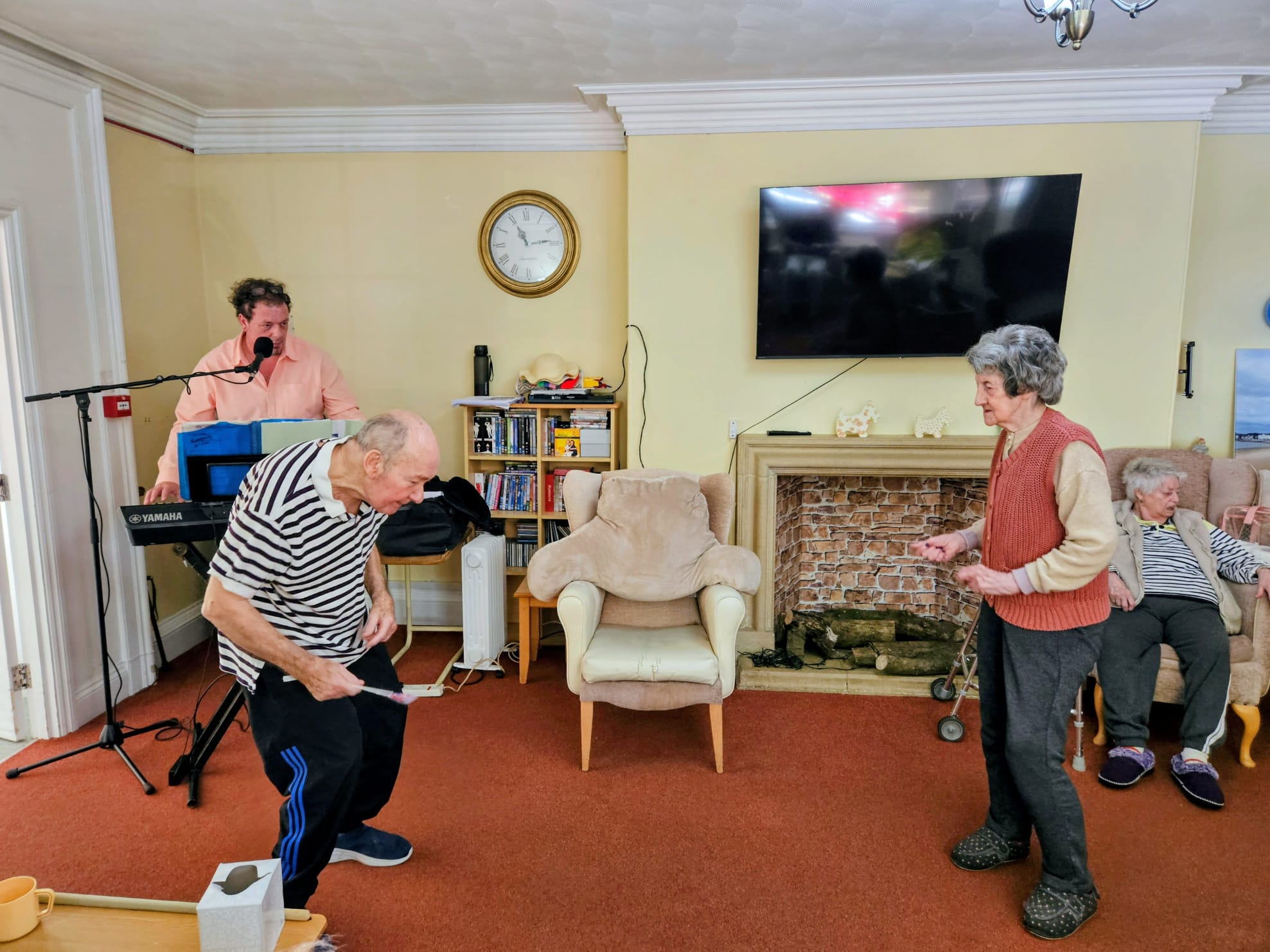 Residents inside dancing to music from a man playing the keyboard