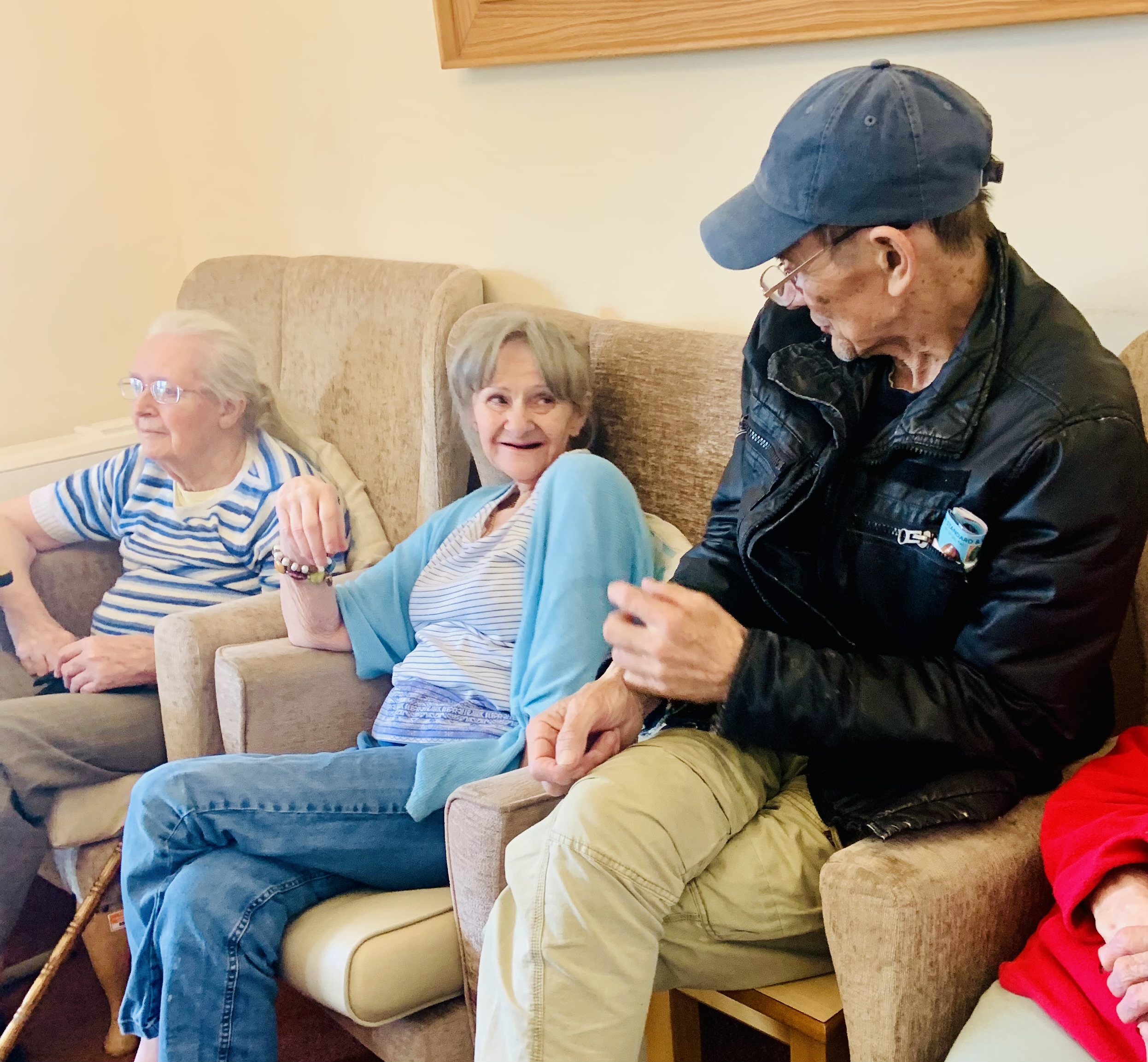 Residents seated in armchairs chatting 