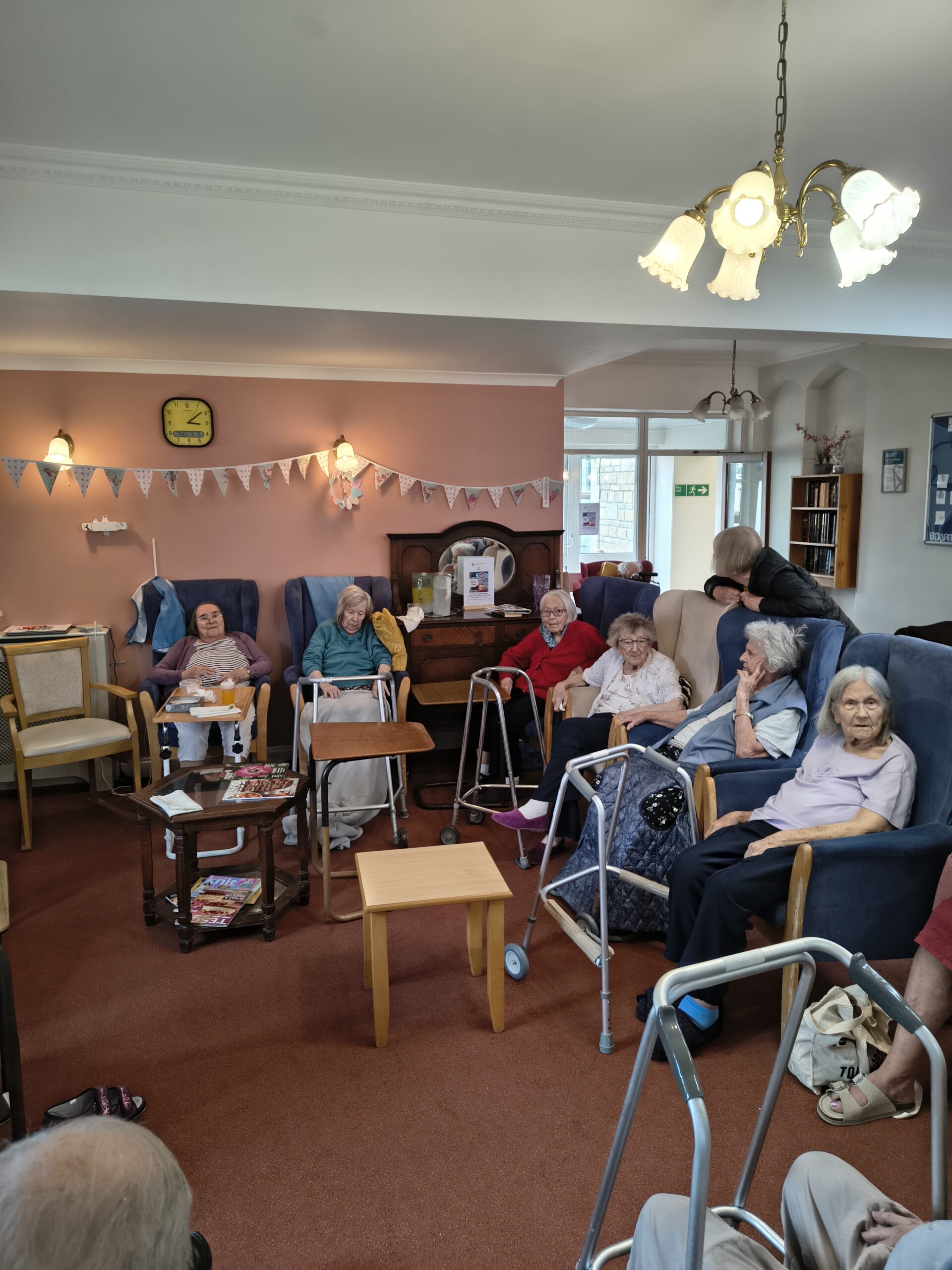 Residents seated together in armchairs chatting scaled