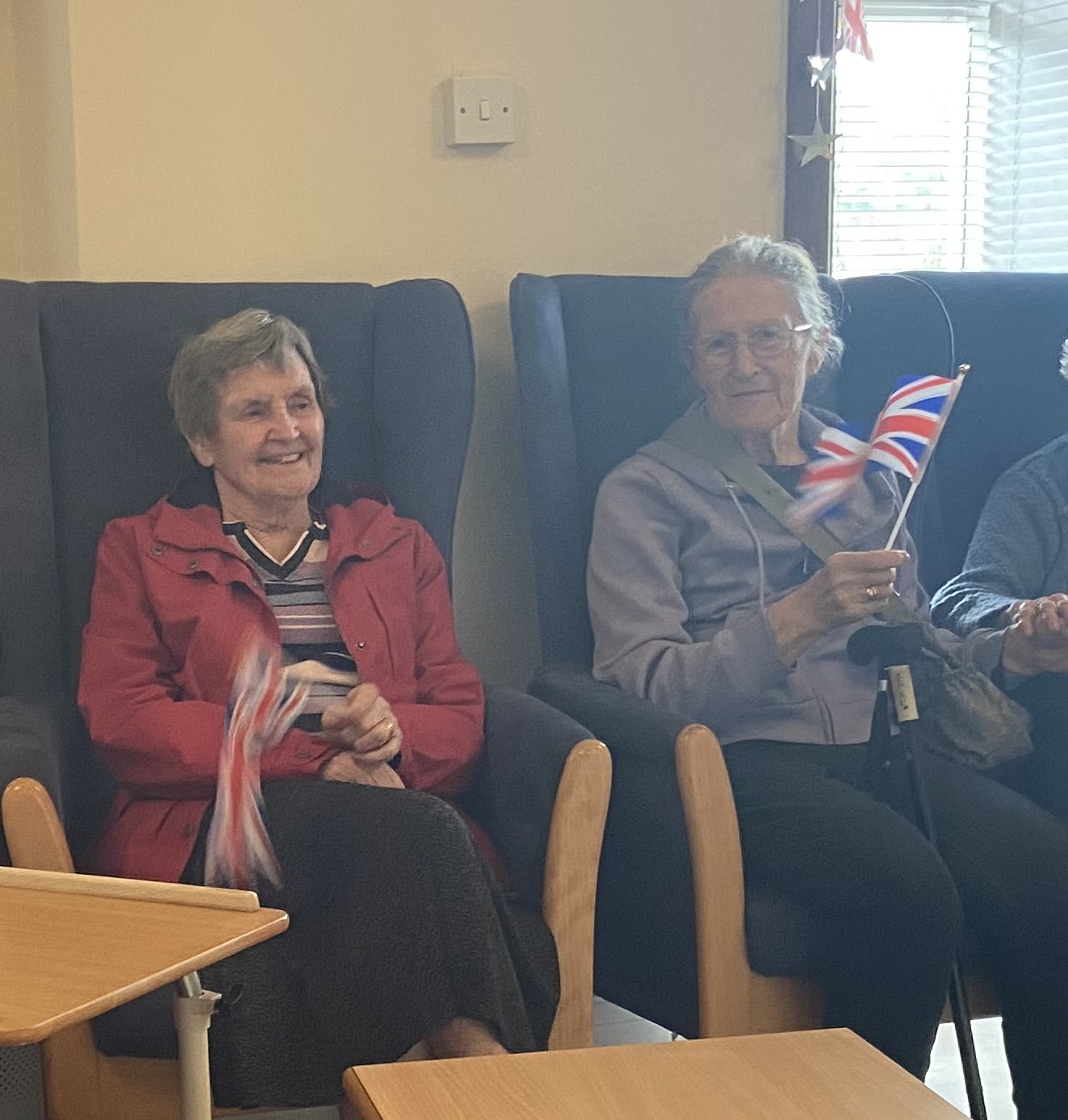 Residents seated waving Union Jacks to the music