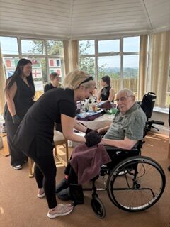 Students setup in the conservatory one male resident having his massage rotated