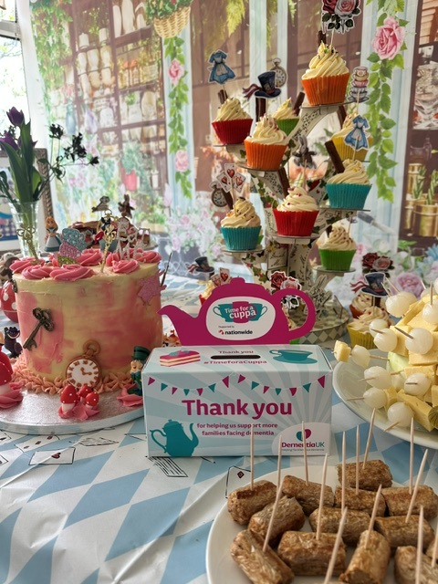 Table laid out with cakes cupcakes and Mad Hatter decorations 2