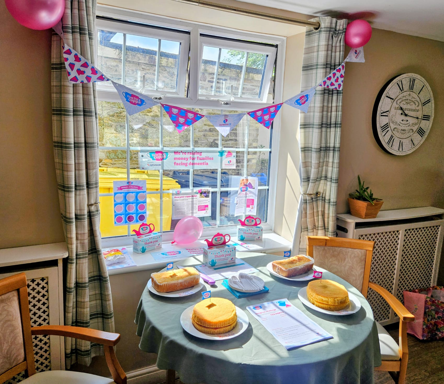 Tables of cakes and donation box with bunting and balloons