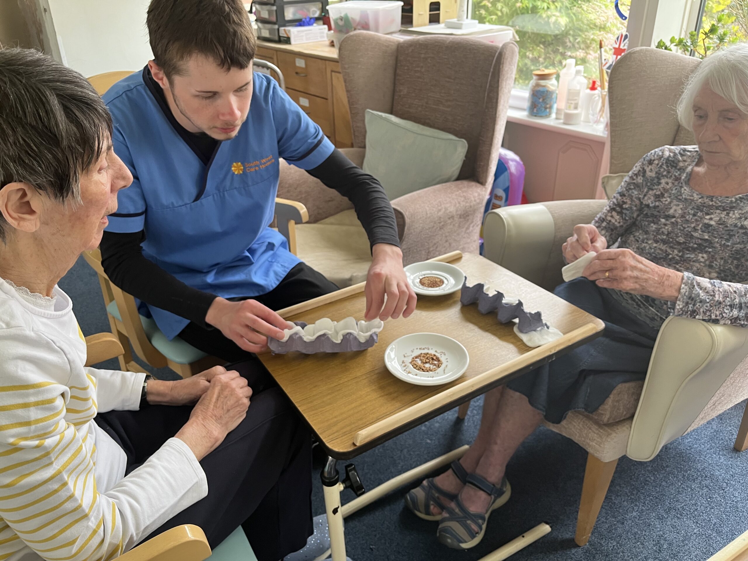 Violet carer Archie and Jean working together getting the seeds ready scaled